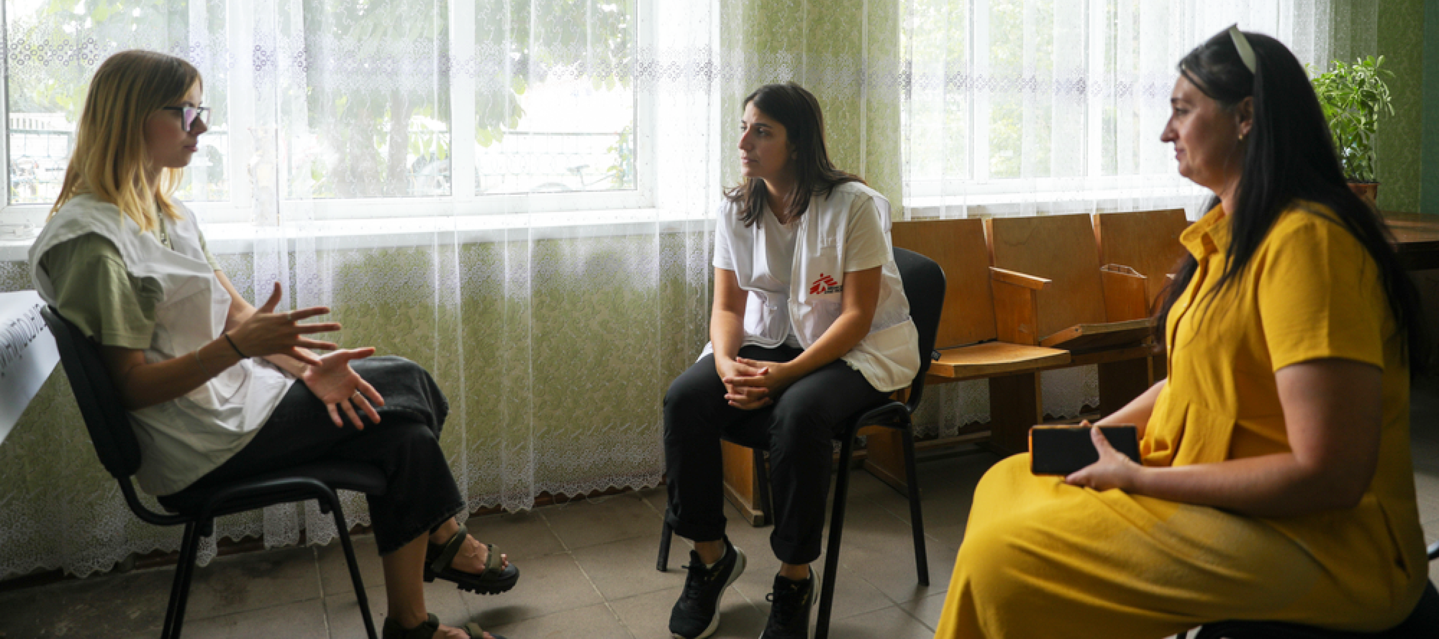 Drei Frauen in Stuhlkreis im Gespräch miteinander, eine ist Projektkoordinatorin